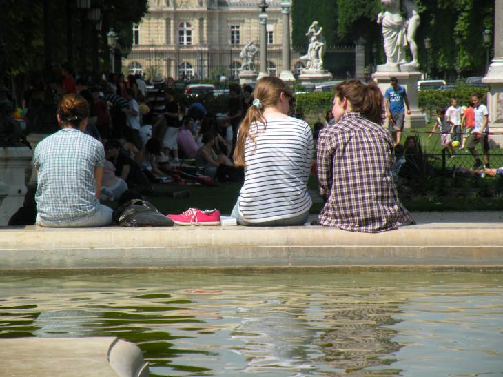  jeunes femmes assises sur le rebord de la Fontaine du jardin des explorateurs